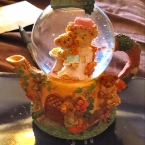 Snow globe shaped like teapot with teddy bears.